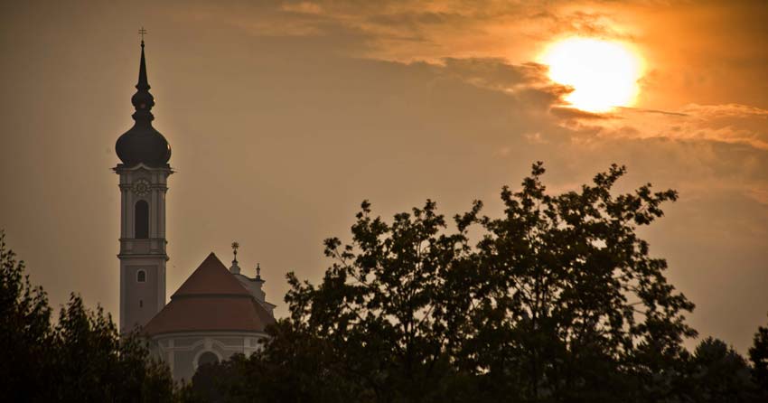 Watching the sun set over the silhouette of a church in Diessen.